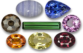 Dans le sens des aiguilles d'une montre en partant du haut à gauche : Agate, Tanzanite, Spinelle, Rhodolite, Grenat du Mali, Saphir, Quartz Fumé et Tourmaline