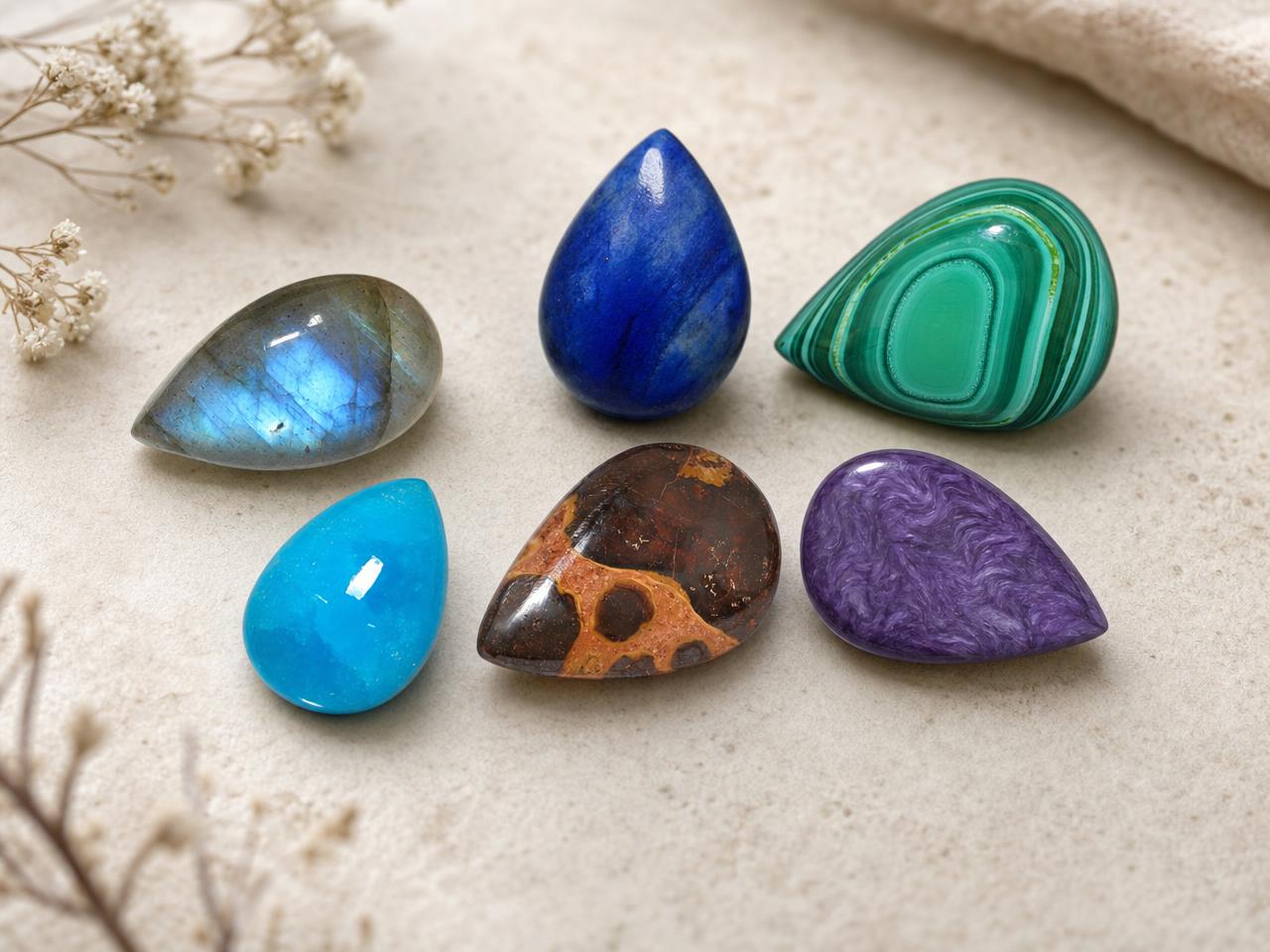 Pierres précieuses cabochon en forme de larme, de couleurs naturelles assorties.